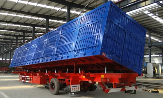 Rear view of the trailer with the side-tipping gate open and hydraulic linkage visible