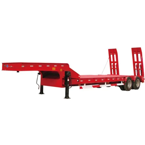 Trailer loaded with heavy industrial equipment on a gravel yard