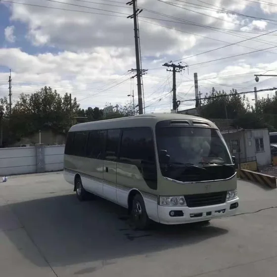 Front three-quarter view of a white 12m electric tour bus with 23 seats, showing the monocoque body and air suspension