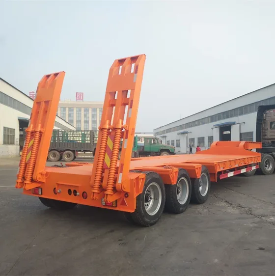 3-axle gooseneck lowboy trailer parked on a yard, front three-quarter view showing the hydraulic ladder and kingpin
