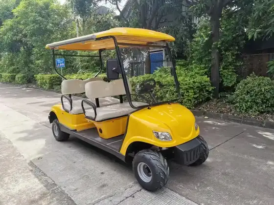 Red 4-seater electric golf buggy parked on a grassy area, front three-quarter view