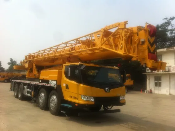 Front three-quarter view of a white QY50KA truck crane with extended boom and hydraulic system visible