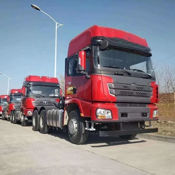 Red 6x4 tractor head parked on a yard, front three-quarter view with MAN H3000-style cab