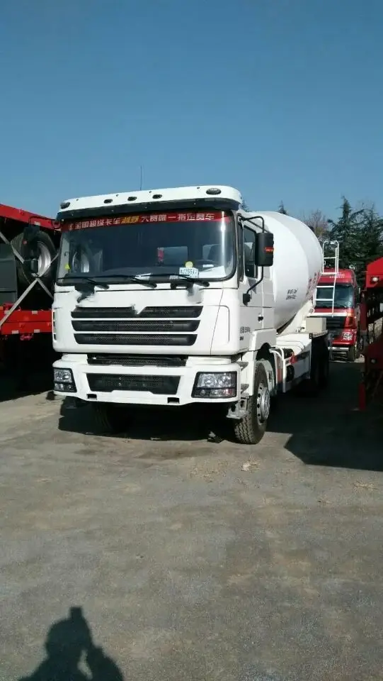 White 8cbm concrete mixer truck parked on a yard, front three-quarter view showing the HOWO70 cab and mixer drum