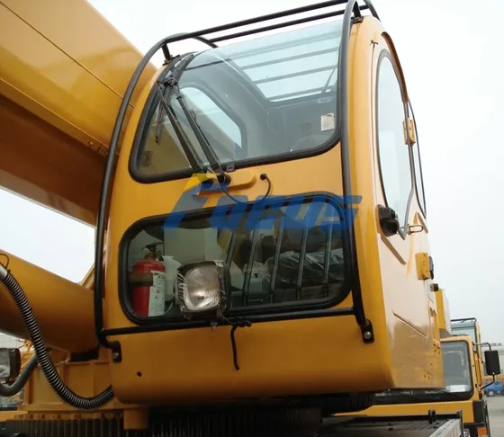 Cab interior with operator seat, controls, and safety harness