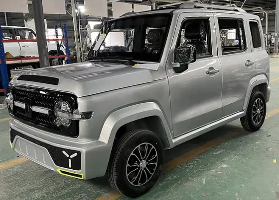 White mini electric SUV with five doors and four seats parked on a concrete yard, front three-quarter view