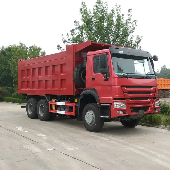 Front three-quarter view of a red HOWO 6x4 mining dump truck on a yard