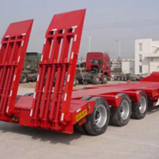 White low bed semi-trailer with 3 axles, parked on a yard, front three-quarter view