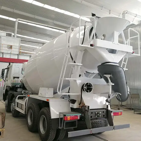 Rear view of the mixer truck with the discharge chute, mud flaps, and fifth wheel coupling