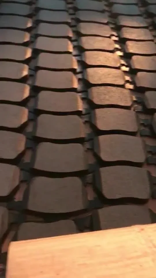 Front brake pad D1950 mounted on a brake caliper, showing the chamfered edge and slot design