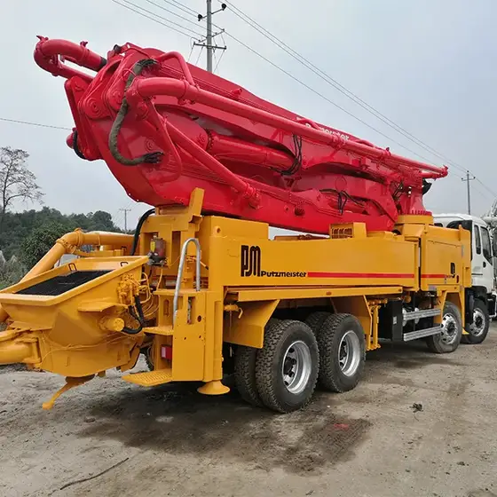 Rear view of the truck showing the 4-axle chassis, cab, and hydraulic system components