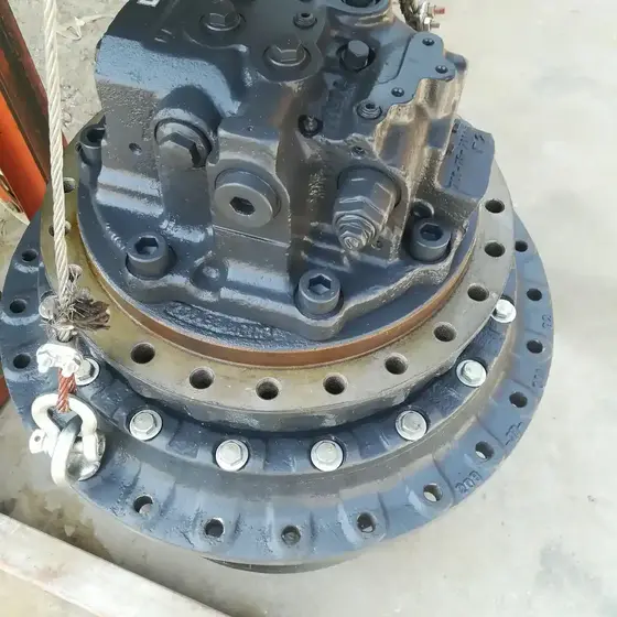Side view of the complete final drive unit with hydraulic connections and mounting bolts