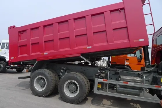 Rear view of the dump truck with the tailgate open and fifth wheel coupling