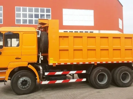 Rear axle and tyre detail of the 6x4 dump truck on a flat yard