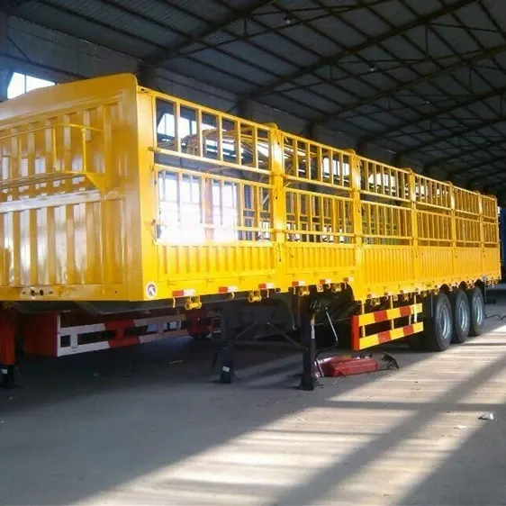 Side view of a 3-axle stake semi-trailer with fence-style side walls and panel doors, parked on a yard