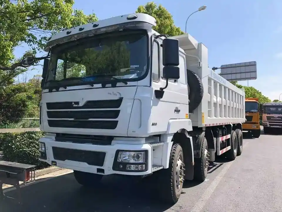 White Sinotruk HOWO 8x4 dump truck parked on a yard, front three-quarter view