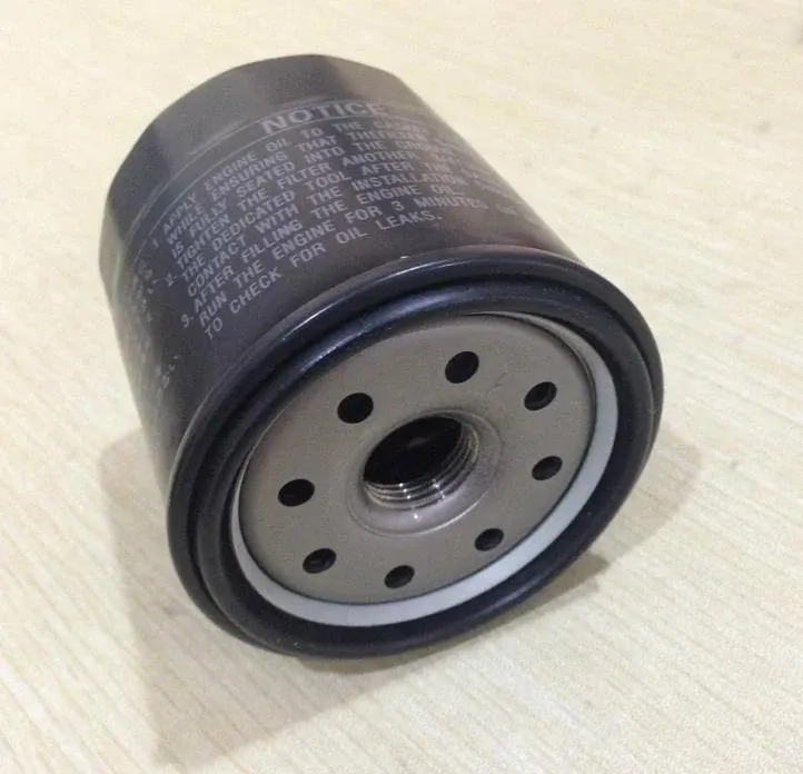Black iron oil filter 90915-YZZD2 mounted on a Toyota engine, front view showing thread and sealing ring