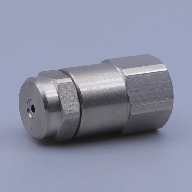 Close up of a silver metal fitting with a hex body and threaded connection on a plain background