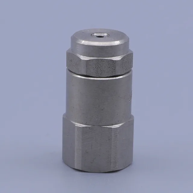 Stainless steel hexagonal fitting with a central orifice on a plain background