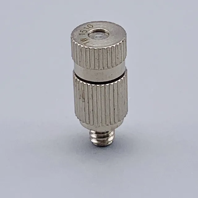 Close-up of a silver metal component with knurled sections and a central threaded opening
