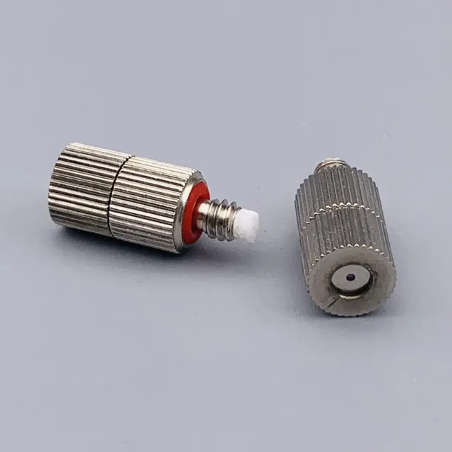 Two knurled metal pneumatic fittings with red seals on a gray background