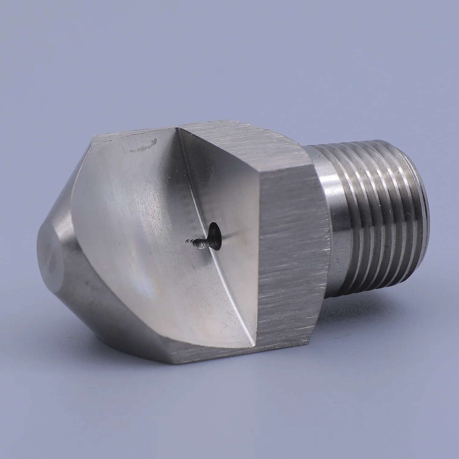 Stainless steel spray nozzle with hex body and threaded connection on blue background