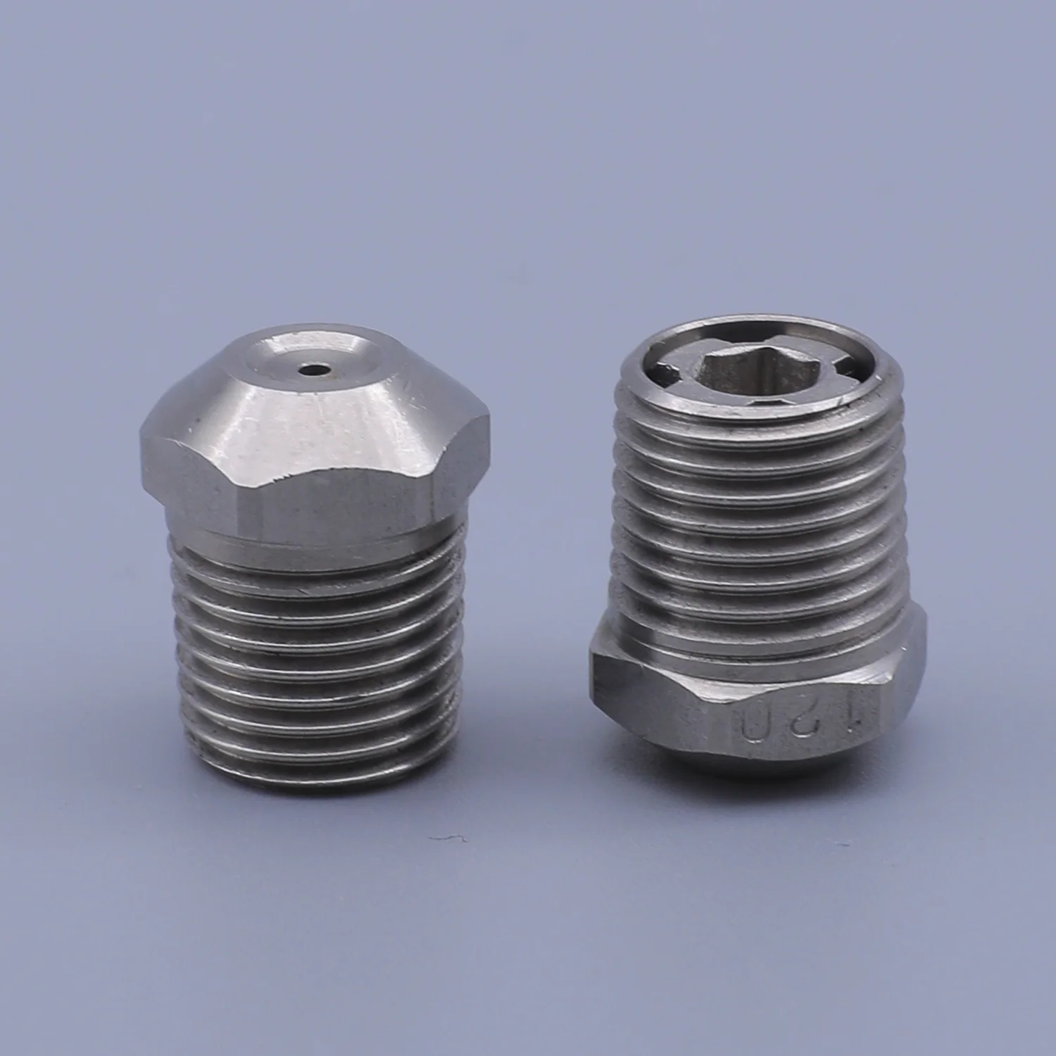 Two stainless steel threaded nozzles with hexagonal bases and internal star fittings