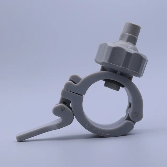 Grey plastic hose clamp with a lever and an attached valve fitting on a plain background