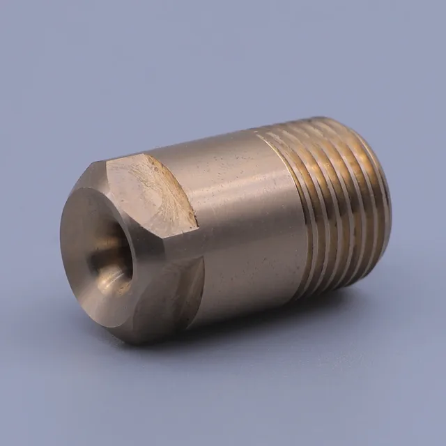 Brass threaded fitting with hex section and internal bore on gray background