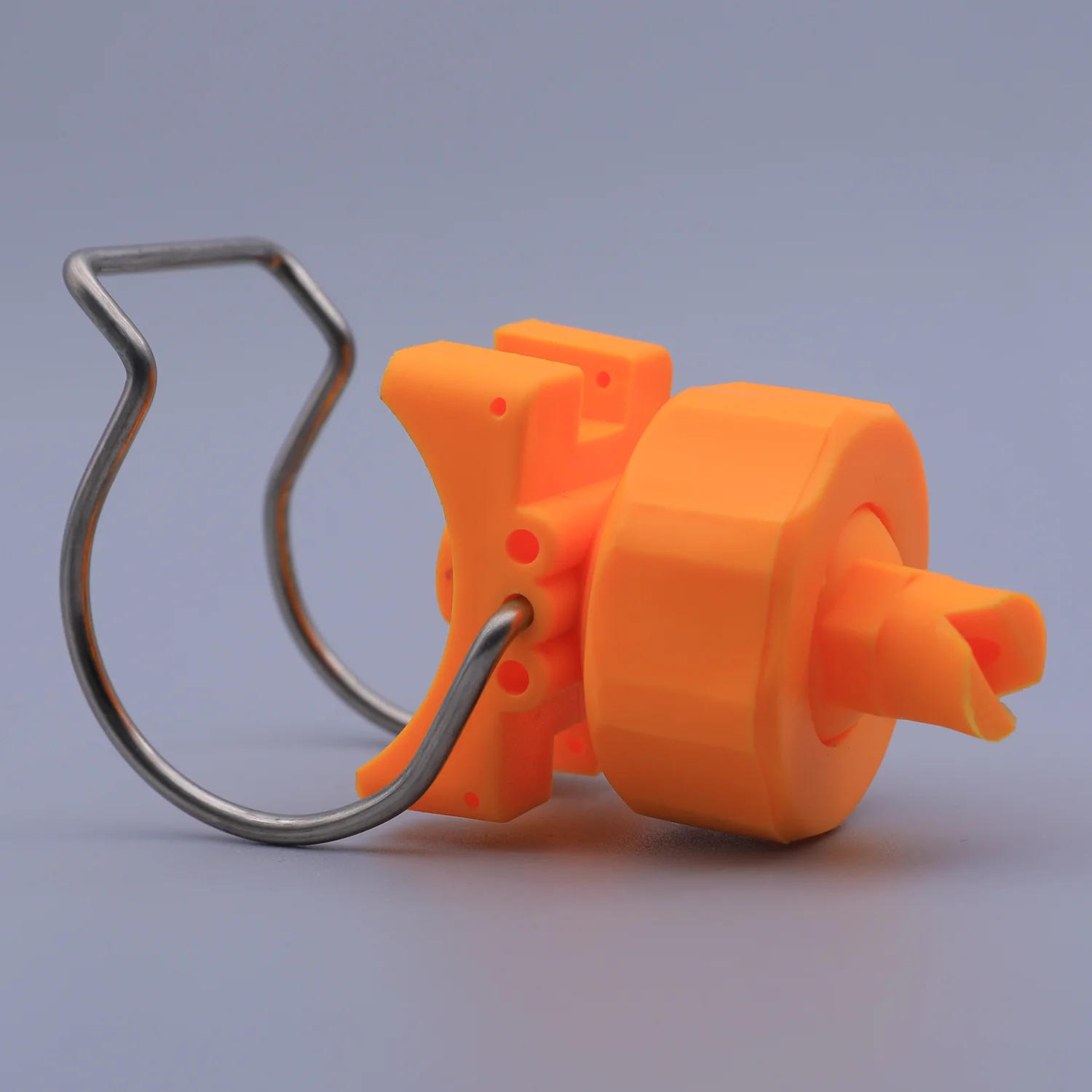 Orange plastic and metal tool with a wire handle and a pointed nozzle