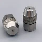 Two stainless steel spray nozzles with knurled collars and hexagonal bases resting on a grey background