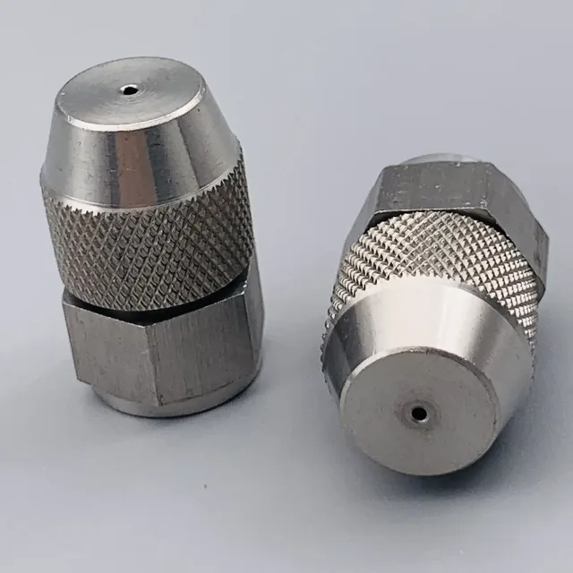 Two stainless steel nozzles with knurled grips and hex bases on a gray background