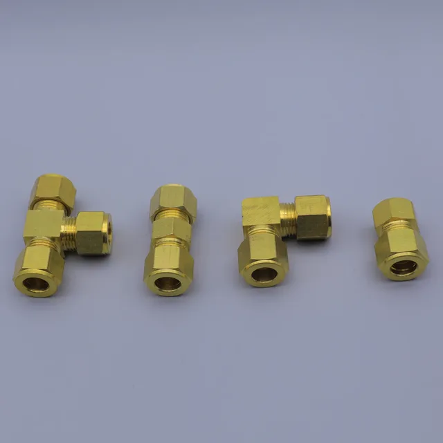 Assortment of brass compression fittings, including tees, elbows, and straight connectors, on a gray background