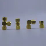Four brass compression fittings arranged in a row on a gray background