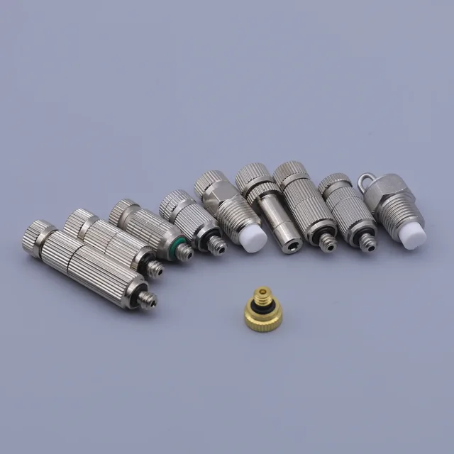 Assorted stainless steel and brass RF coaxial connectors arranged on a gray background