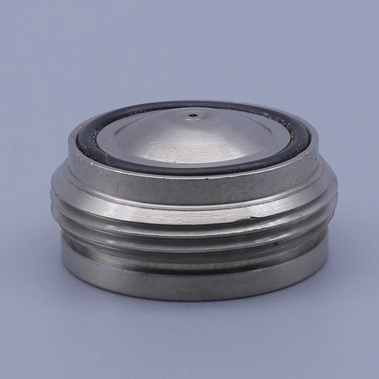 A threaded metal cap with a domed top and a black rubber seal ring