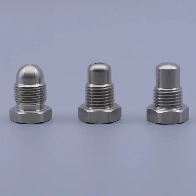 Three stainless steel threaded hex plugs with dome and cylindrical ends on a plain background