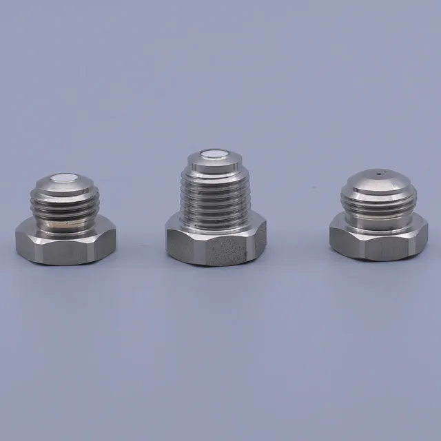 Three stainless steel hexagonal threaded caps arranged in a row against a solid blue background