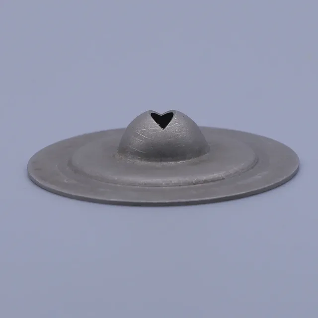 Grey metal disc with raised central dome featuring a heart-shaped cutout