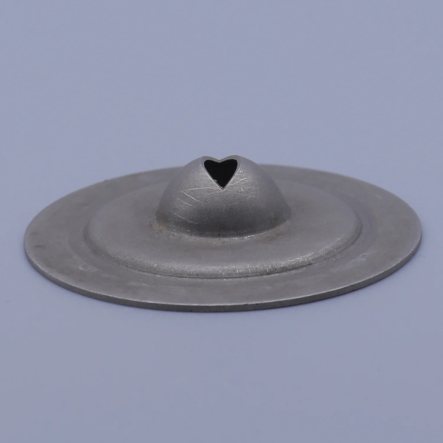 Gray metal vent cap with a heart-shaped opening on a central dome