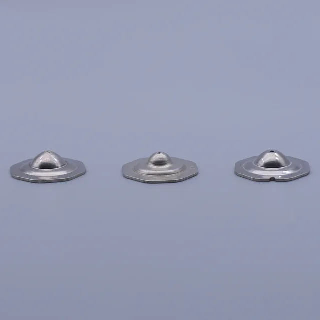 Three silver metallic components with circular bases and dome-shaped tops arranged on a plain background