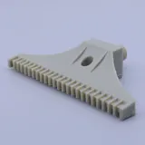 Beige plastic component with a comb-like edge and a cylindrical connector on a white background