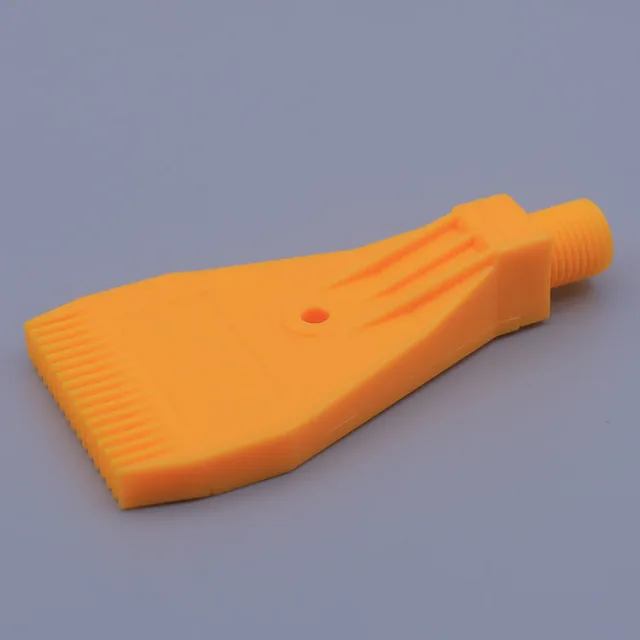 Orange plastic nozzle attachment with threaded connector and flat bristled tip on grey background