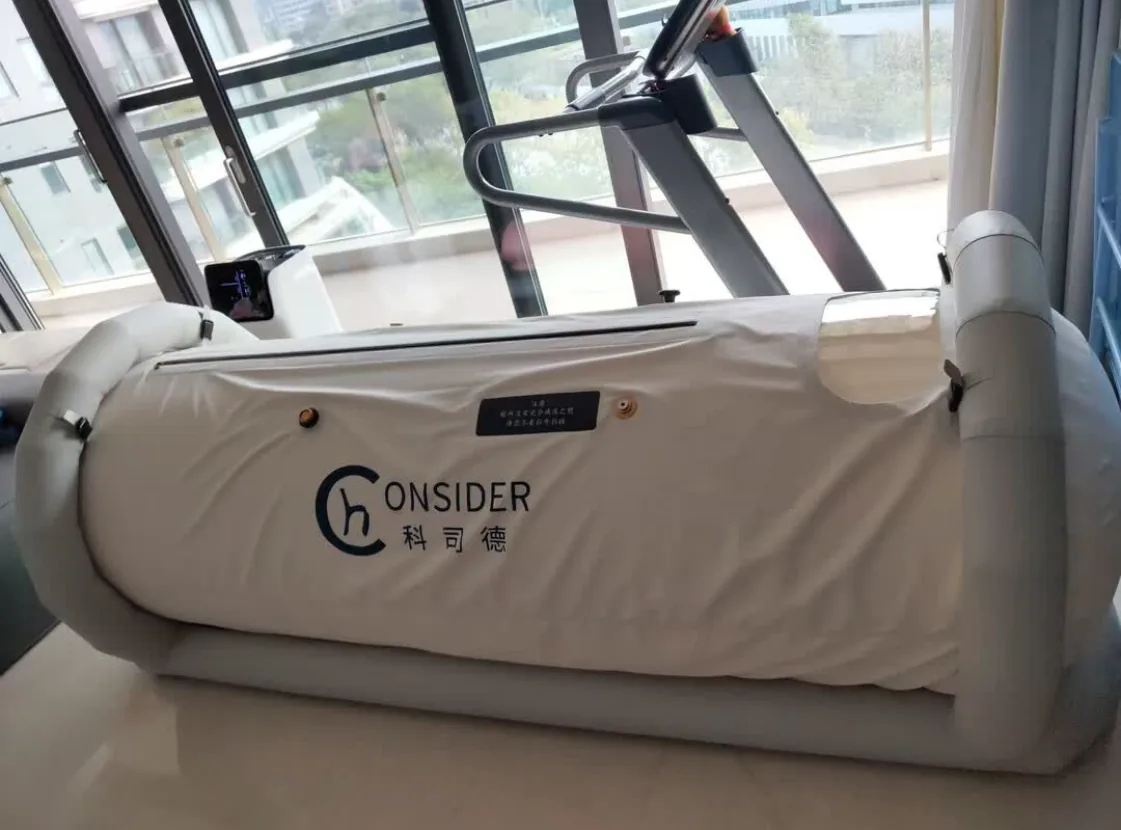 CONSIDER soft hyperbaric chamber installed beside training equipment in a sports studio