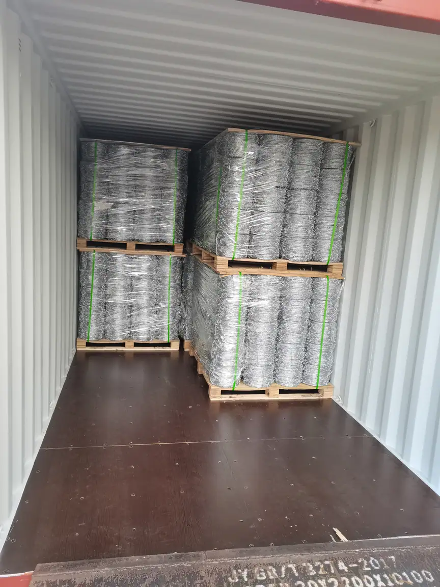 Barbed wire coils palletised inside a shipping container