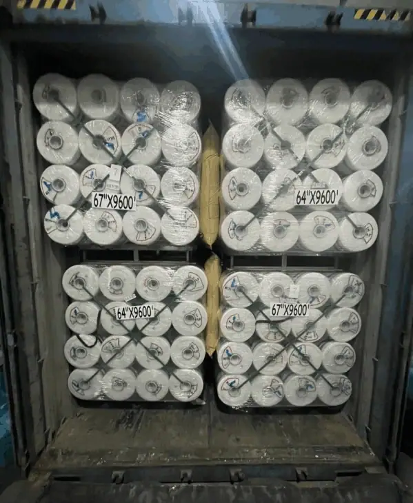 Bale net wrap pallets being loaded into a shipping container