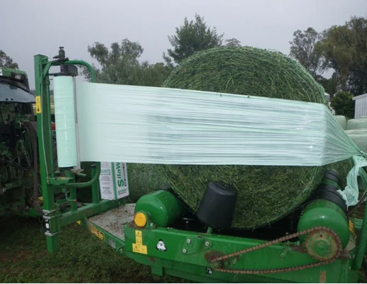 Silage wrap film being applied to a green forage bale
