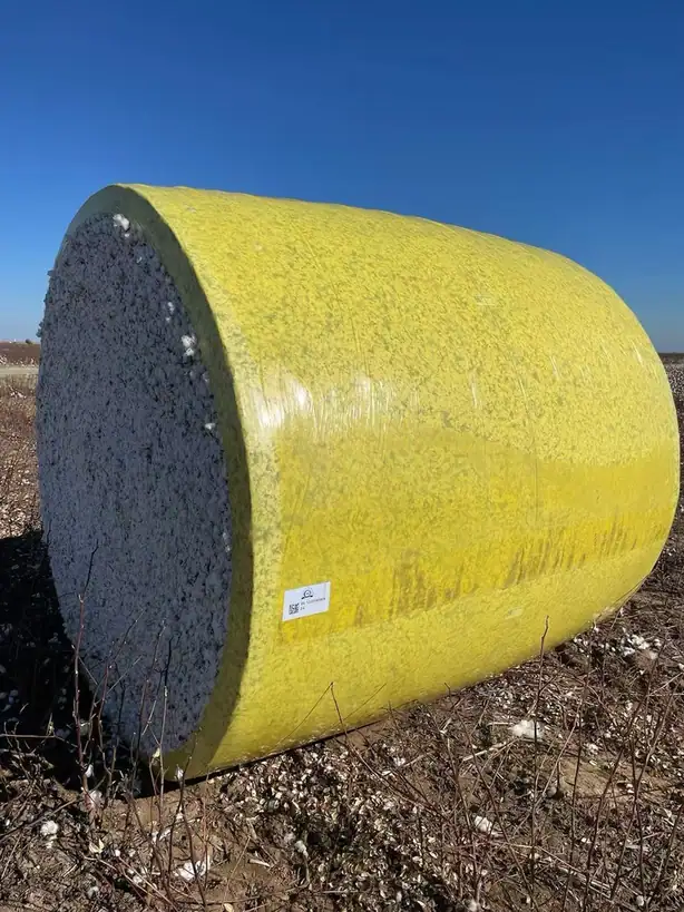 Yellow wrapped round cotton module at the end of a picking run