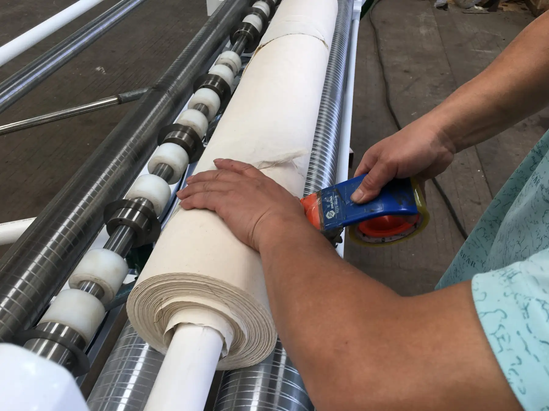 Operator feeding cloth into a CRA-500 bias fabric cutting and rolling machine