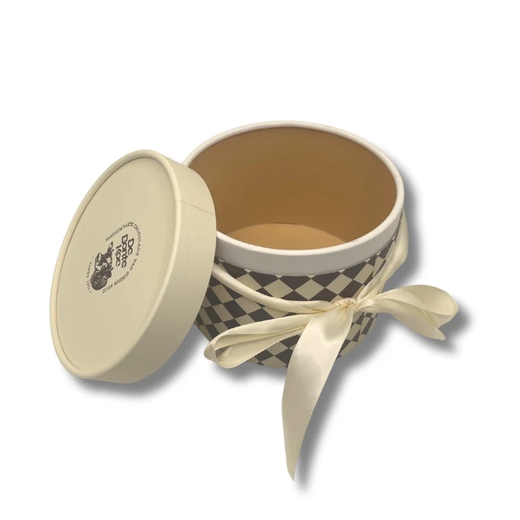 Round chocolate box shown open with pralines in cavities